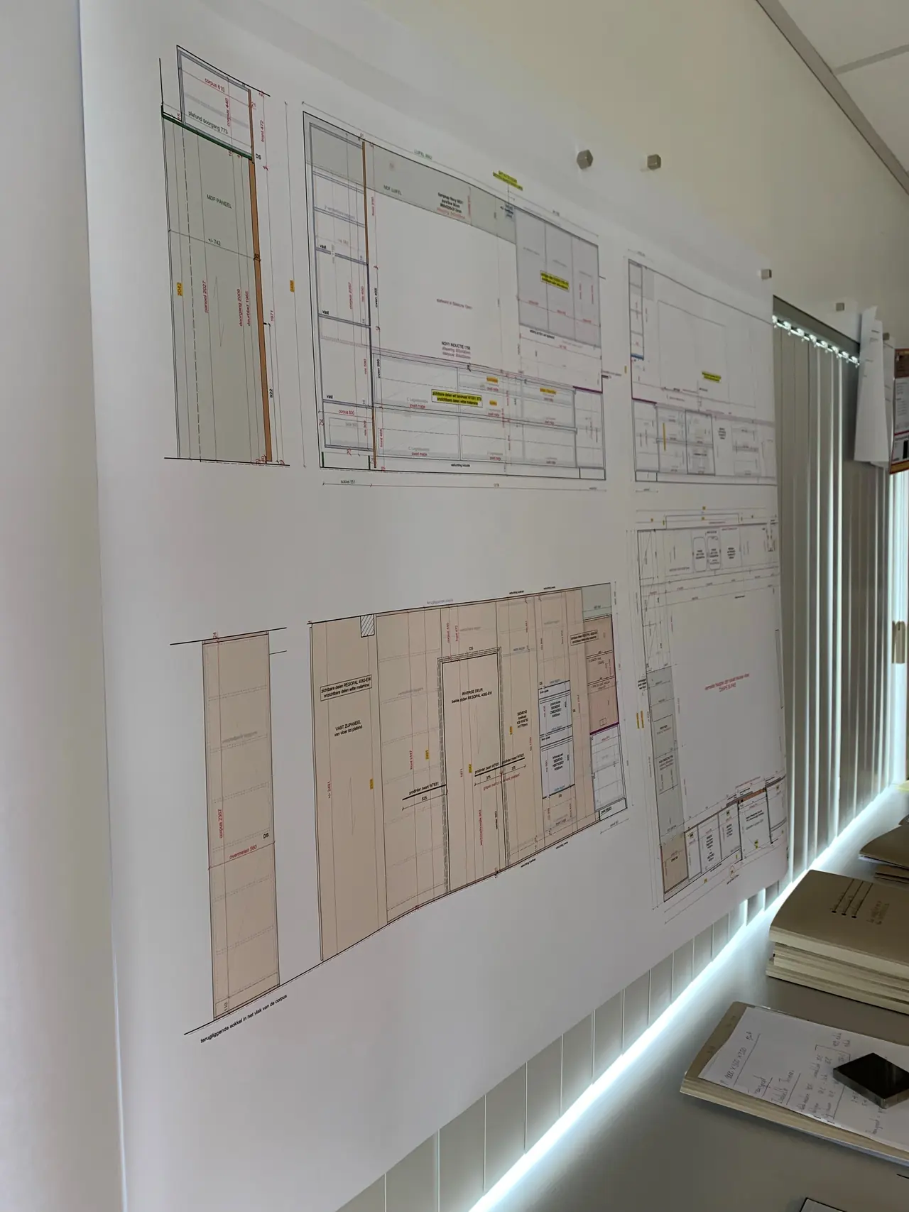 Werktekeningen van lopende projecten aan de muur