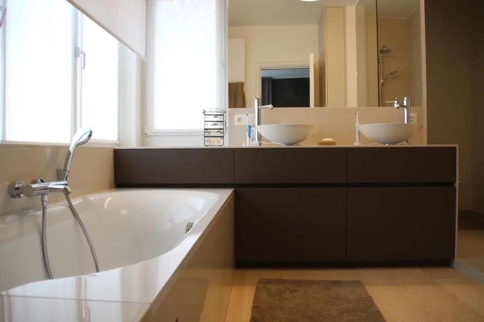 Badkamer met ligbad en donker houten meubel