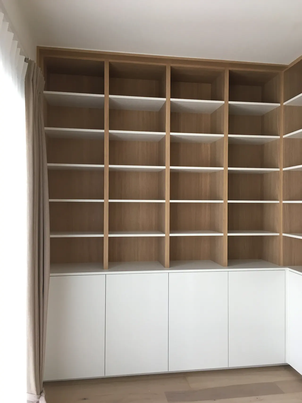Hoge boekenkast in eik met witte onderkasten