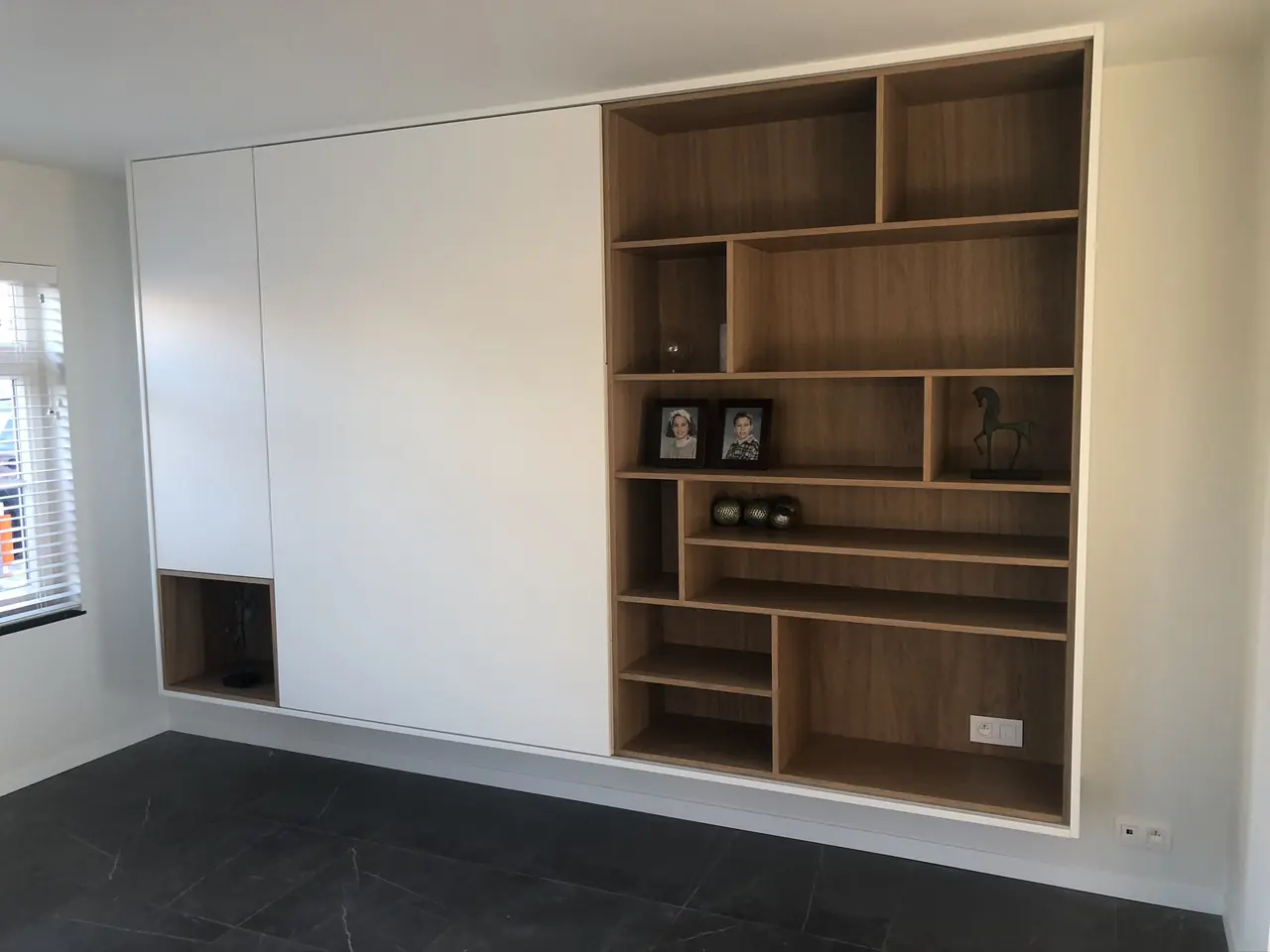 Witte kastenwand met open vakken in eikenfineer