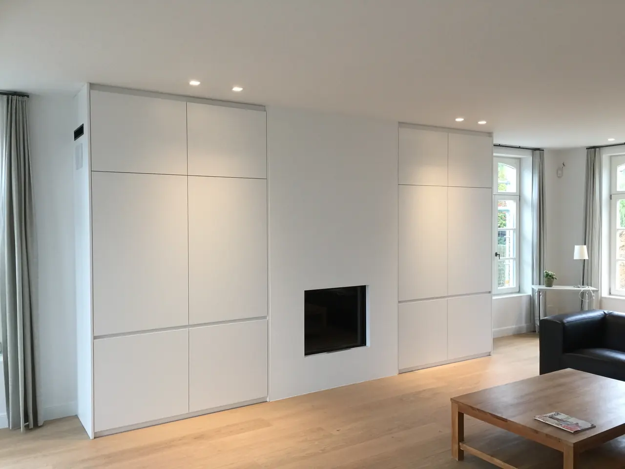 Witte kastenwand met ingebouwde haard in een woonkamer