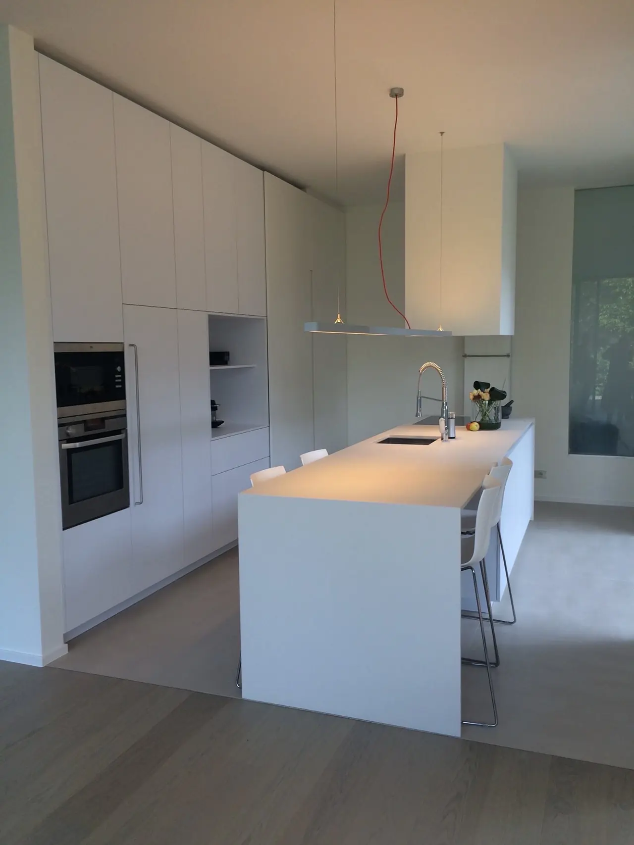 Wit keukeneiland met hoge inbouwkasten