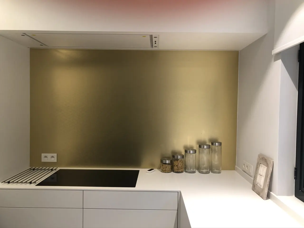 Witte keuken met messingkleurige achterwand