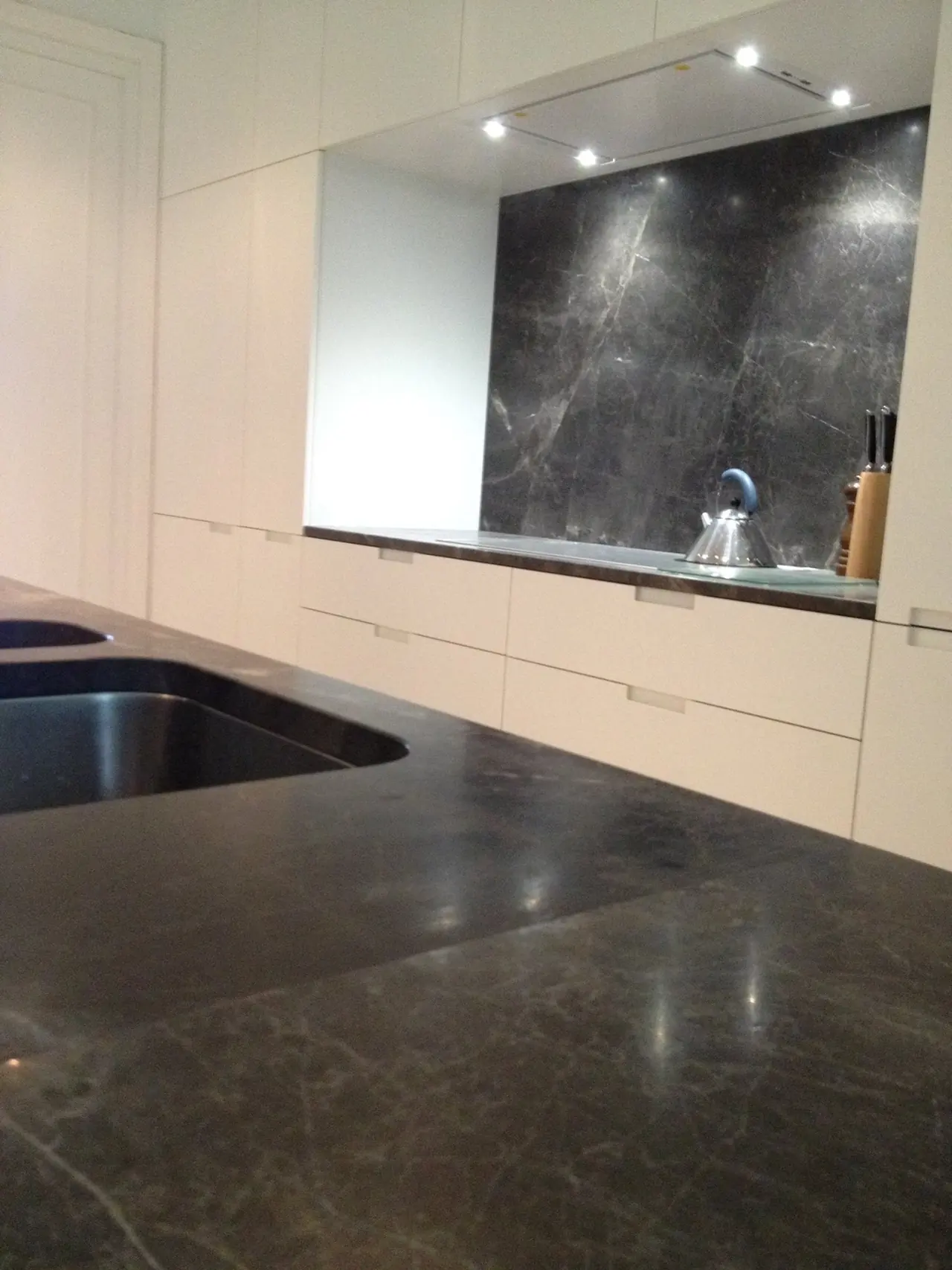 Keuken met donker natuursteen werkblad en achterwand