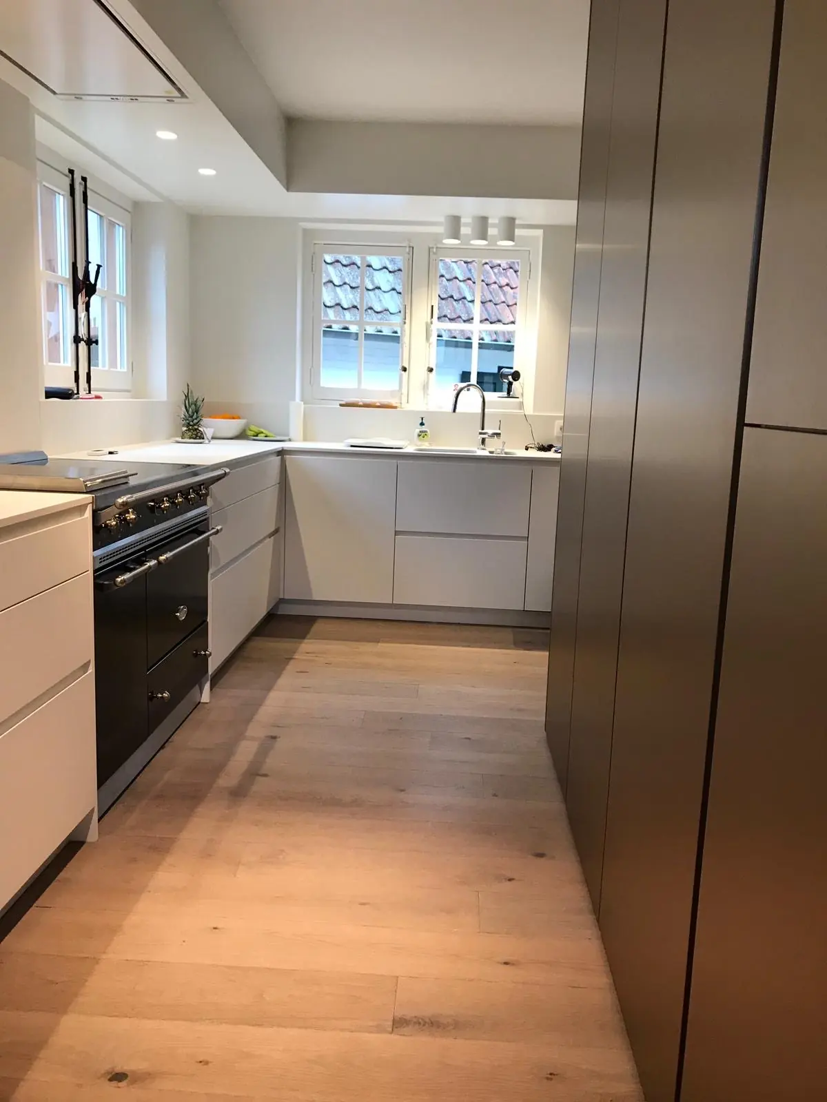 U-vormige keuken met eiken vloer en donkere kolomkasten