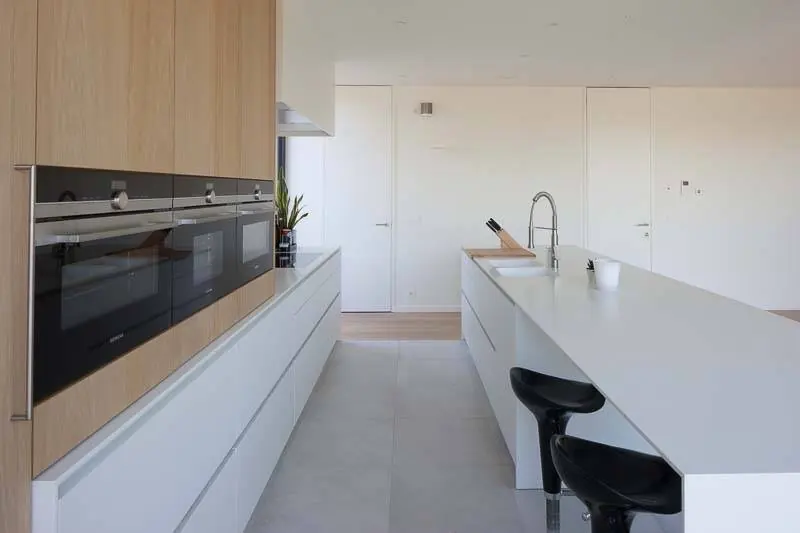 Strakke witte keuken met eiken accenten en kookeiland