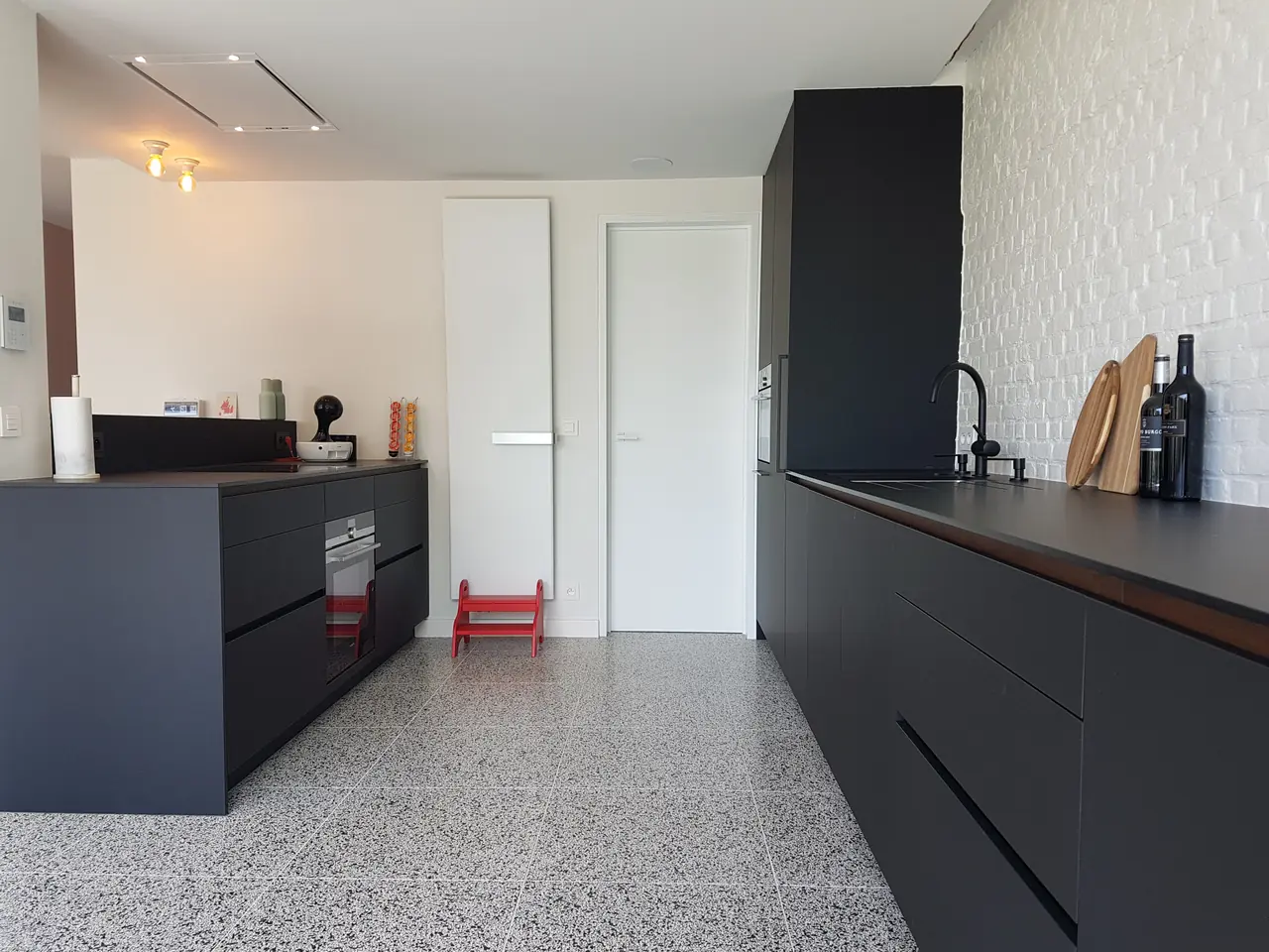 Zwarte keuken op een terrazzovloer