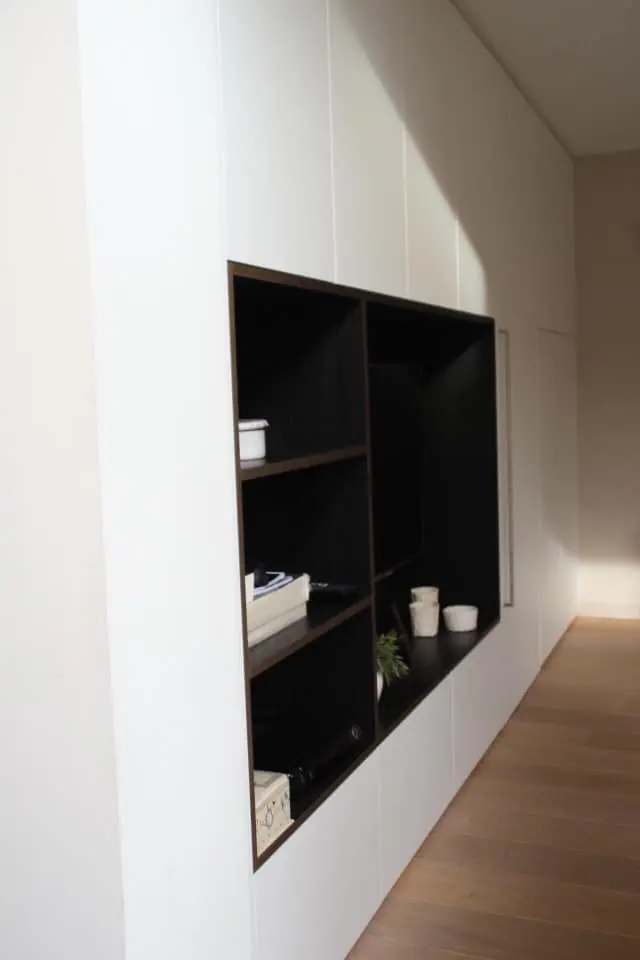 Witte wand met ingewerkte zwarte open kast