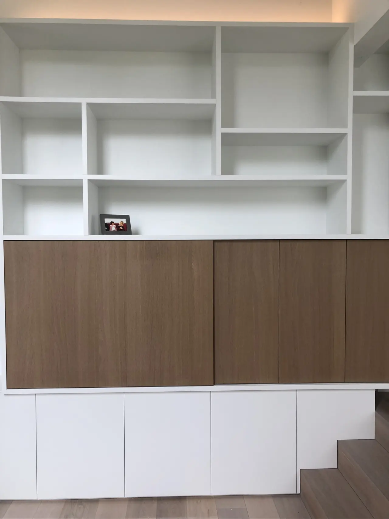 Wandkast met witte open vakken en deuren in eikenfineer